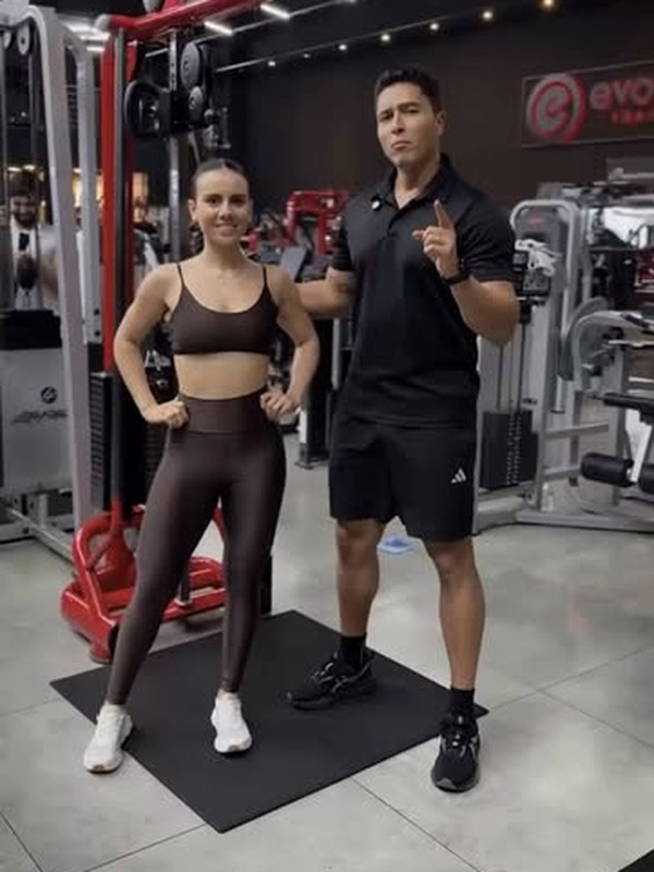 Jhonathan Guimarães orientando uma aluna na academia